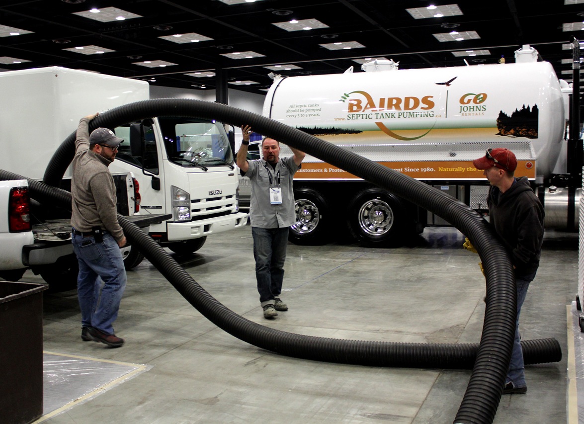 Exhibitors at the WWETT Show take hose off a truck as setup continues at the Indiana Convention Center.